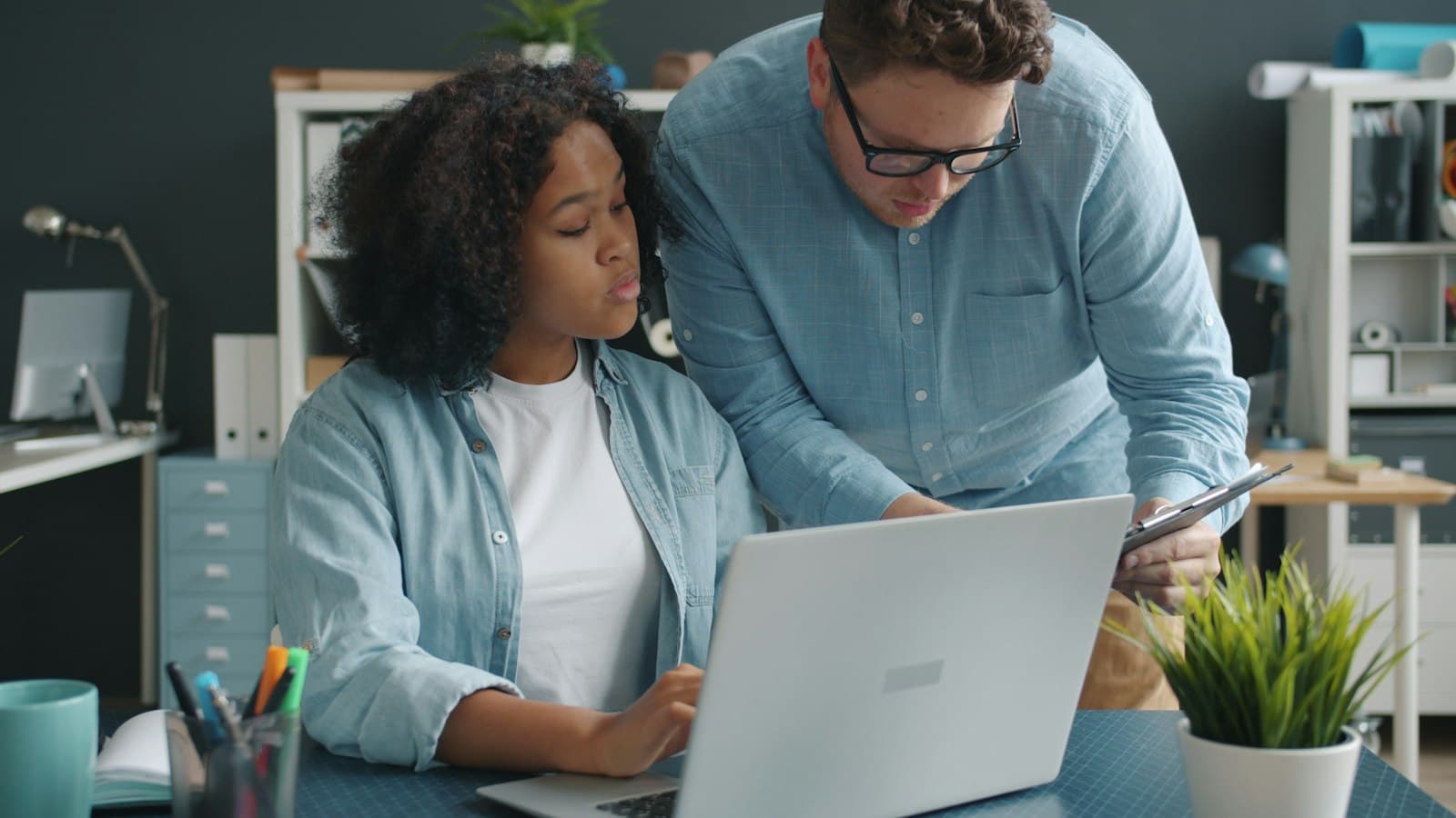 A mentor reviewing a student's work on her laptop